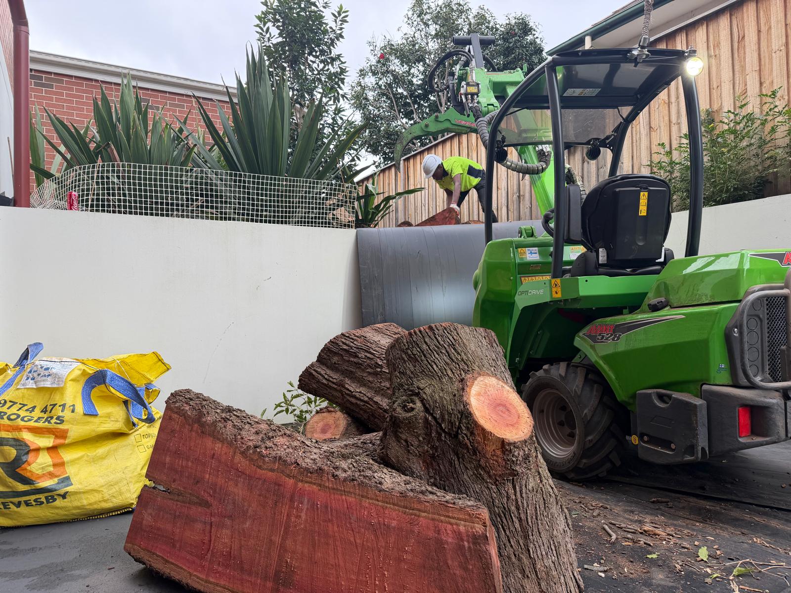 True Roots crew chipping a removed tree beside the Avant loader in a Strathfield driveway